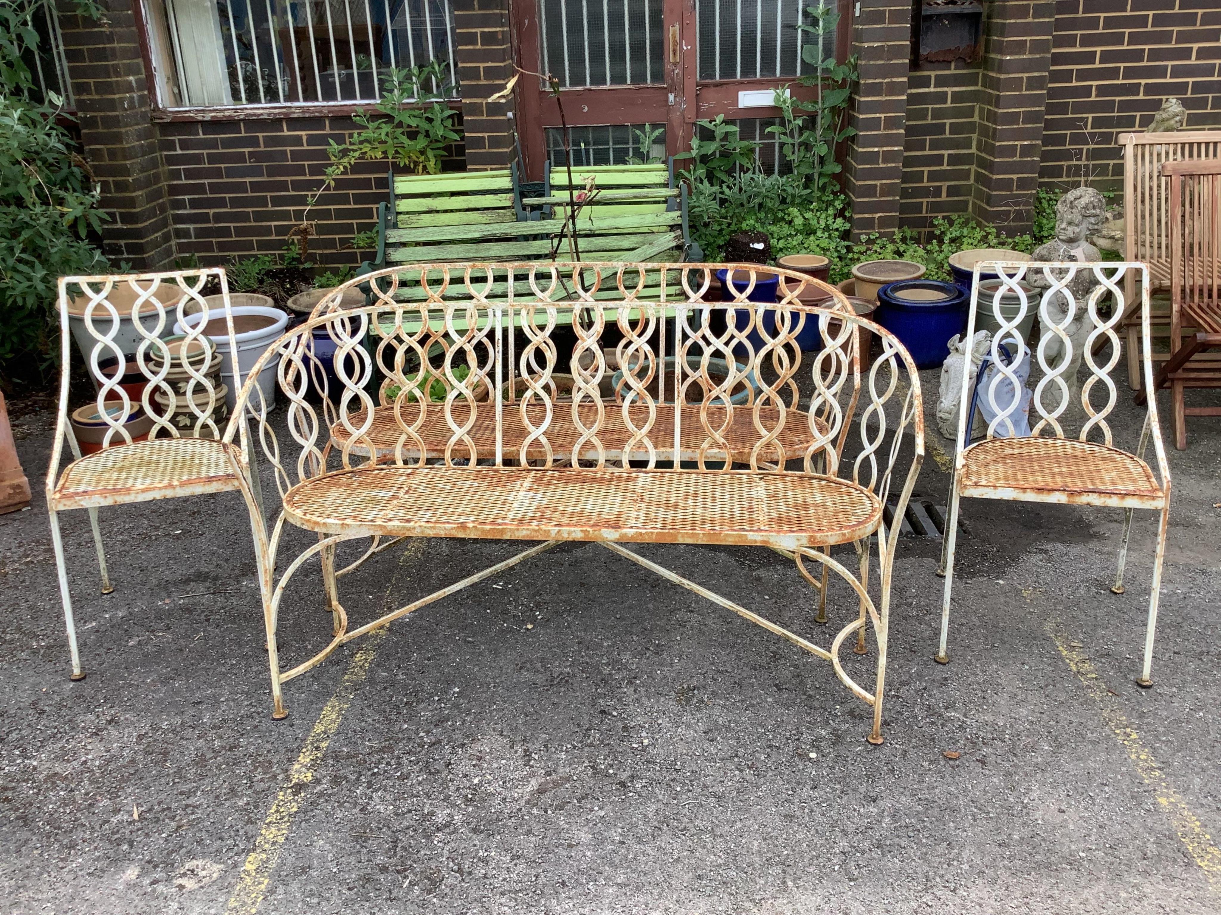 A vintage painted wrought iron four piece garden suite comprising a pair of benches, width 141cm, depth 38cm, height 84cm and a pair of matching chairs